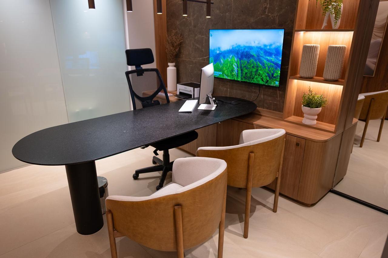 Consultório com mesa, poltronas e iluminação acolhedora